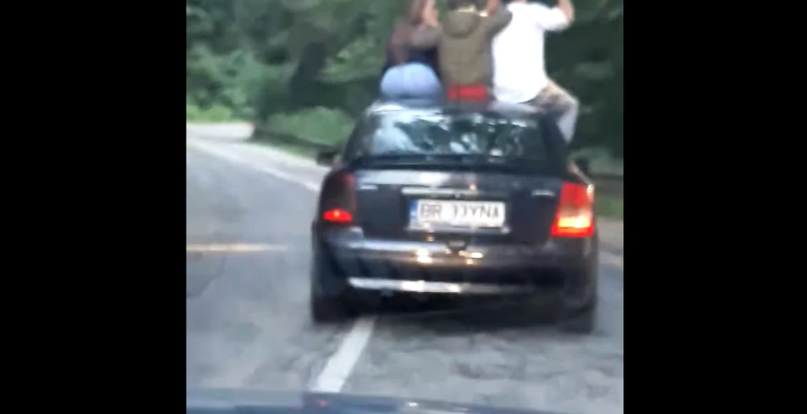 Patru tineri filmaţi pe capota unei maşini aflate în mers – VIDEO