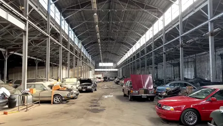 O hală plină cu mașini abandonate. Mai multe BMW, Mercedes-Benz și Volvo, lăsate să adune praf - VIDEO