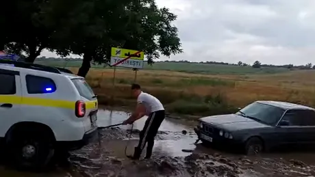 Operațiune inedită. O Dacia Duster de poliție scoate un BMW din noroi