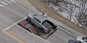 Scene incredibile surprinse în SUA! Două mașini oprite la semafor, înghițite de un crater apărut în asfalt