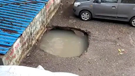 O mașina se scufundă într-o groapă din asfalt pe fondul precipitațiilor abundente - VIDEO