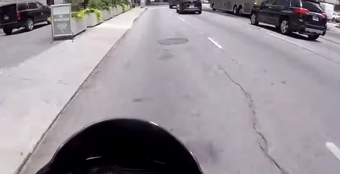 Un şofer îi taie calea unui motociclist care îi aterizează pe capotă şi apoi îi sparge parbrizul – VIDEO