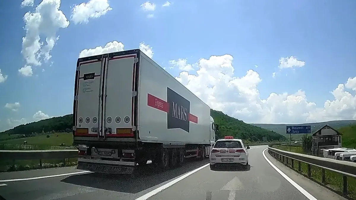 La un pas de accident. Un șofer de TIR depășește în curbă pe linie continuă