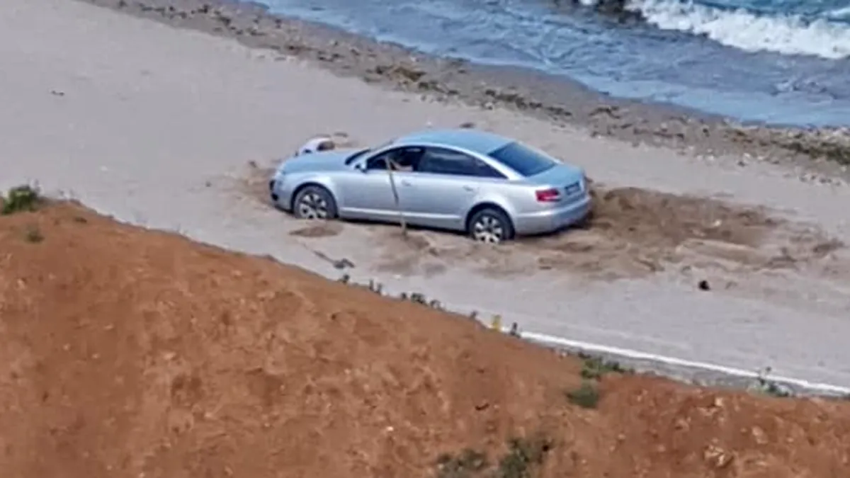 Un Audi a rămas blocat în nisip la Olimp. Ca în fiecare an marea își cere tribut - FOTO