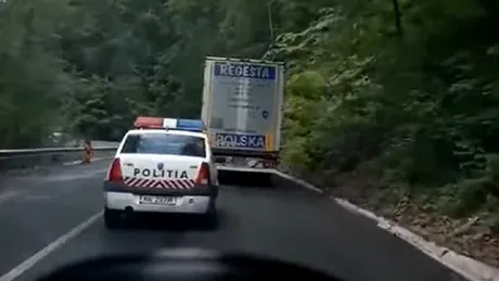 O mașină de poliție a fost filmată în timp ce face o depășire într-o curbă periculoasă - VIDEO