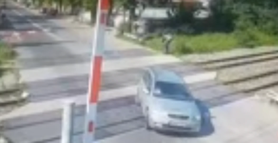 La un pas de accident în Bucureşti. Un şofer traversează la limită calea ferată, lovind o barieră – VIDEO
