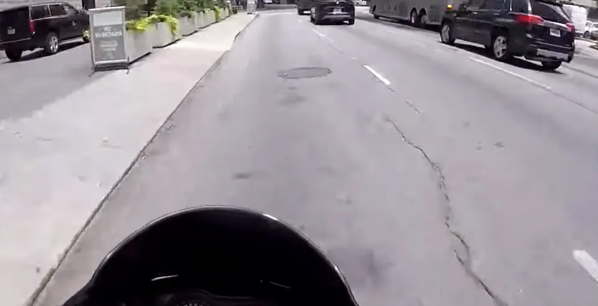 Un şofer îi taie calea unui motociclist care îi aterizează pe capotă şi apoi îi sparge parbrizul – VIDEO