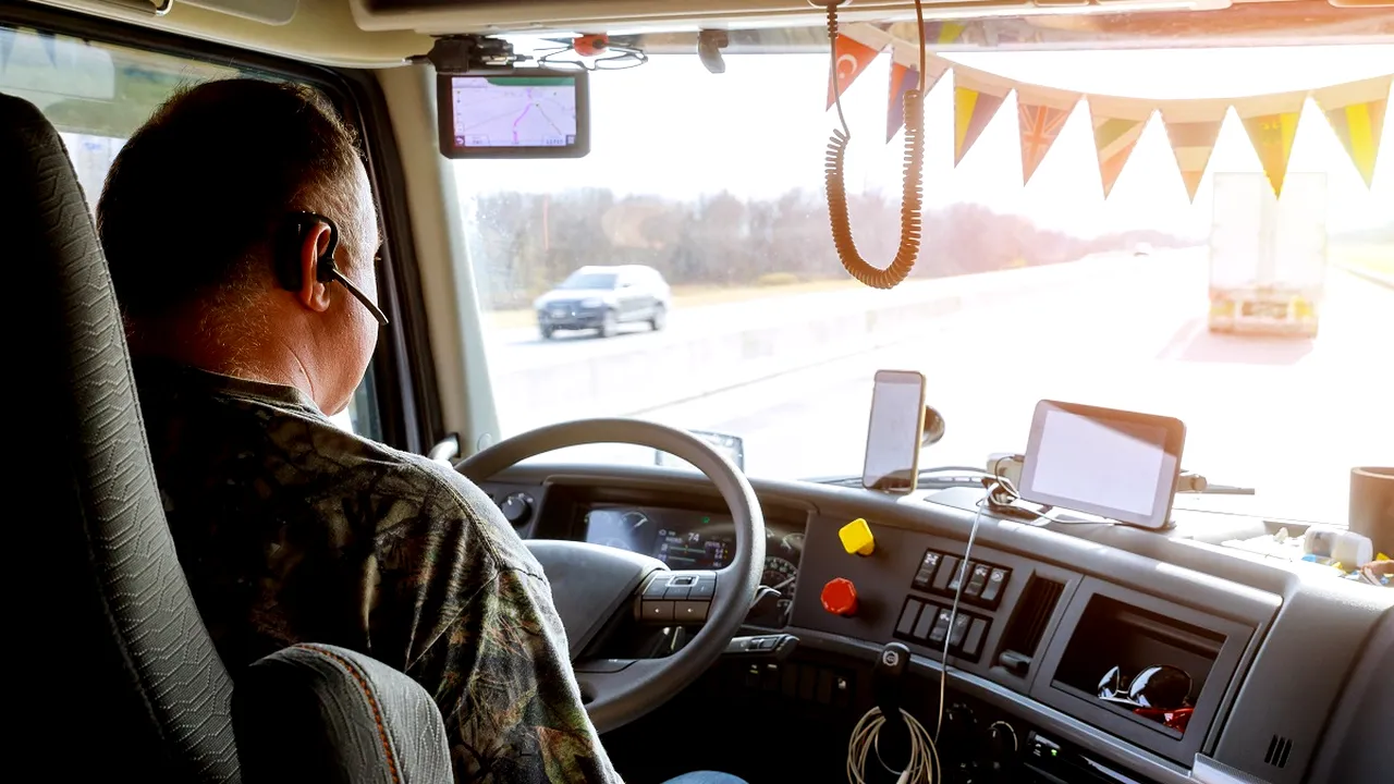 Driver in cabin of big modern truck 