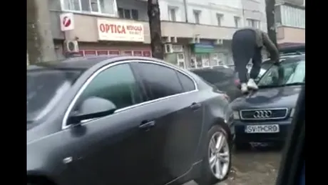 Un bărbat se urcă pe mașină pentru a ocoli bălțile formate după ploaie - VIDEO