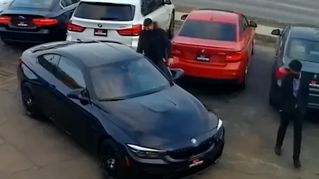 Un bărbat a furat un BMW M4 dintr-un parc auto. În fuga sa l-a ”plimbat” pe capotă și pe dealerul auto - VIDEO