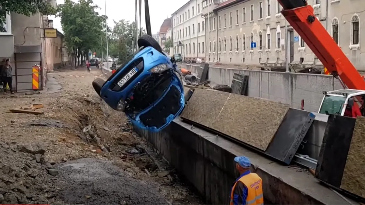 A încercat să meargă în marșarier și a căzut într-o groapă. A doua zi, i-au scos mașina cu macaraua