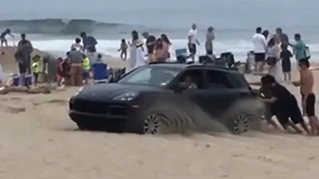 Un Porsche a rămas blocat în nisip printre turiștii aflați la plajă