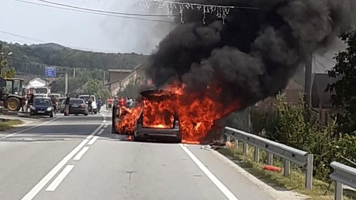 Un autoturism BMW a luat foc în mers pe o șosea din Gorj - FOTO