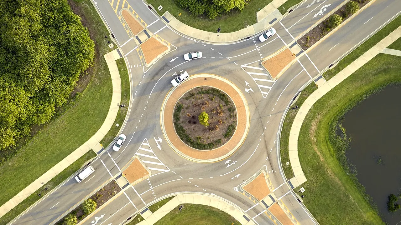 Aerial view of road roundabout intersection with moving cars traffic. Rural circular transportation crossroads 